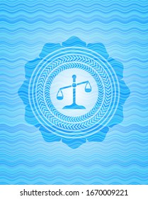 scale icon inside light blue water emblem background.