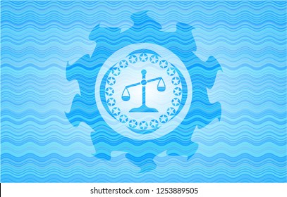 scale icon inside water wave emblem.