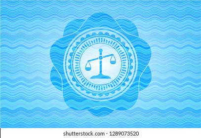 scale icon inside water wave representation emblem.