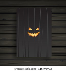 Scary carved pumpkins face card on a wooden background