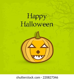 Scary pumpkin on dead tree branch decorated green background for Happy Halloween celebrations. 