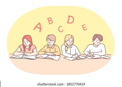 School, lesson, learning letters and alphabet, education concept. Group of positive concentrated children classmates sitting with books and learning letters of english alphabet in classroom 