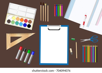 School supplies are lying on a brown wooden table. 