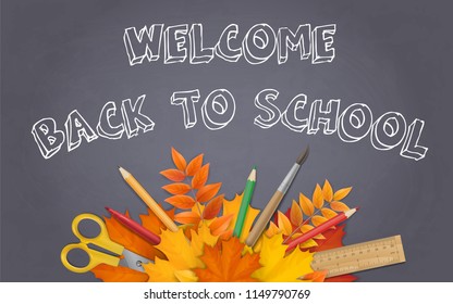 School supplies and maple leaves on black on black chalkboard background. Welcome back to school background with space for advertising text.