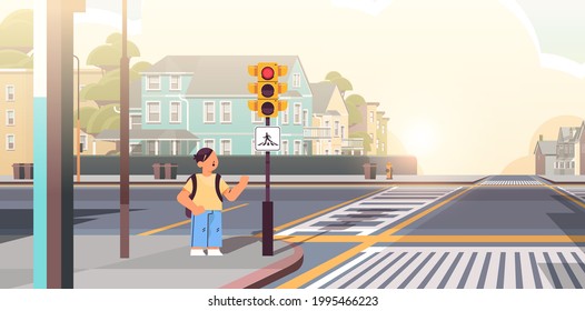 escolar con mochila esperando que el semáforo verde cruce la carretera en concepto de seguridad vial