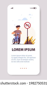 schoolboy with bicycle standing near red round kike ban sign road safety concept vertical