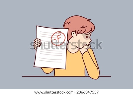 Schoolboy is sad because of poor test score and educational failures caused by lack of motivation to study at school. Boy is upset after receiving exam in primary school and needs help of tutor