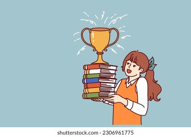 Schoolgirl with books and cup for winning rejoices at good marks for test. Child prodigy girl with golden cup of winner  enjoys prize of best elementary school student