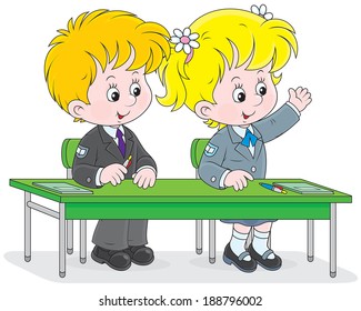 Schoolgirl and schoolboy sitting at their desk and answering a teacher's question at a lesson