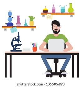 Scientist. Man sitting at table in his office and working on laptop.Workspace.