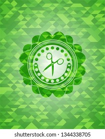 scissors icon inside green emblem with triangle mosaic background