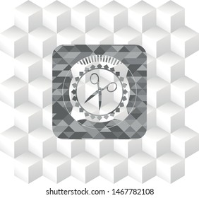 scissors icon inside grey badge with geometric cube white background