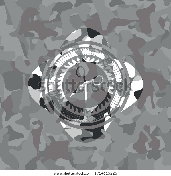 scissors icon\
inside grey camouflaged emblem.\
