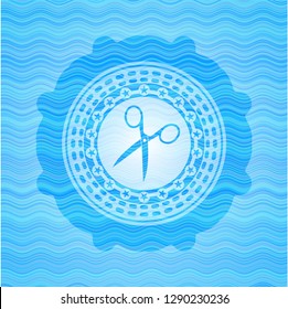 scissors icon inside light blue water wave badge.