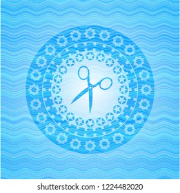 scissors icon inside sky blue water emblem.