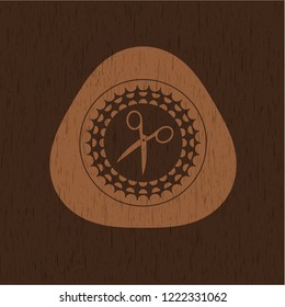 scissors icon inside wood badge or emblem