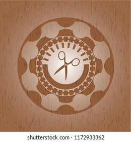 scissors icon inside wooden emblem