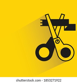 scissors and ribbon with shadow on yellow background