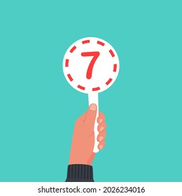 Score card 7. Number table. Digit rating on a scorecard. Human hand holding score card. Colored scorecards. Juries assessment on competition. Judges hold score. Vector design. Isolated on background.