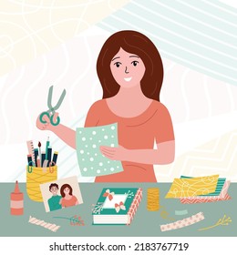 Scrapbooking Hobby. Woman With Craft Supplies. Scrapbook Workshop. Handmade Decoration Things. Smiling Girl With Scissors Cutting Craft Paper Decorating Album Book At Table. Flat Vector Illustration.