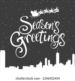 Script font type Season's Greetings for greeting card, Santa Claus flying on the cityscape during winter