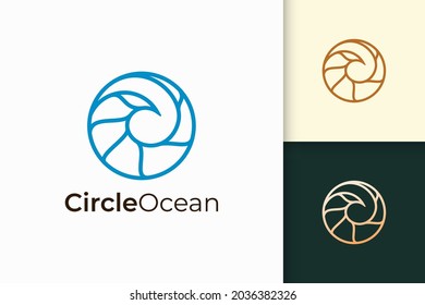 El logotipo marino o oceánico en forma de círculo simple representa la playa o el surf