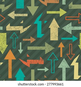 Seamless abstract grange background with big and small multicolored arrows on green