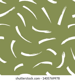 Seamless abstract marks pattern with handmade brushstroke elements on green background.