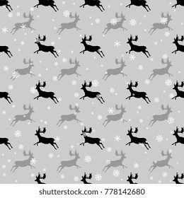 Seamless abstract monochrome pattern with silhouettes of running deer and snowflakes. Cute winter motif.