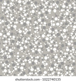 Seamless abstract monochrome pattern with small chaotic ellipses or pebbles.