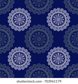 Seamless abstract pattern with geometrical round mandalas in folk style. Croatian ethnic motifs. White and gray lines and dots on indigo blue background.