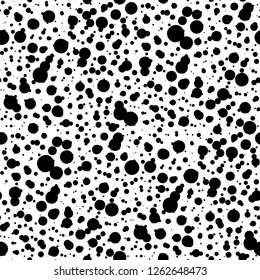 Seamless abstract texture with random black circles or ink blobs.