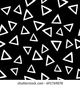 Seamless abstract vector monochrome geometric pattern. White triangles put randomly on black background. Gift wrapping paper. Bed sheets and interior.