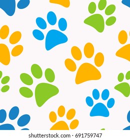 Seamless abstract vector pattern. Blue, green and yellow paws put randomly on white background. Animals theme. Gift wrapping paper. Bed sheets and interior.