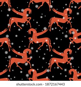 Seamless animal winter pattern with fantastic winged red horses and snowflakes. Folk Russian style. New year Christmas motif.