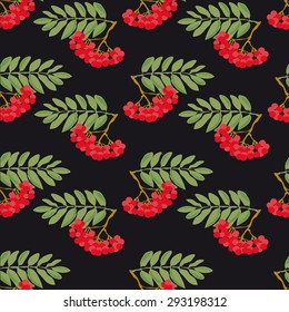 Seamless autumn pattern. A pattern made from the ripe berries of mountain ash and green leaves, on a black background.