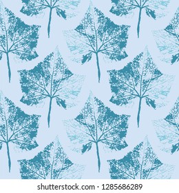 Seamless background of colored plant prints on blue background.
