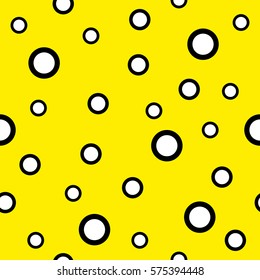 Seamless background consisting of black and white circles of different sizes on a yellow background. Vector illustration.