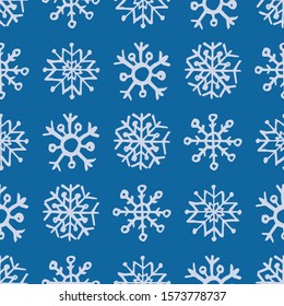 Seamless background of hand drawn snowflakes. White snowflakes on blue background. Christmas and New Year decoration elements. Vector illustration.