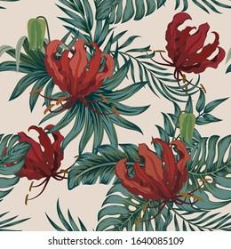 A seamless background made of palm leaves and red Gloriosa flowers