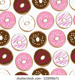 Seamless background pattern of assorted doughnuts, or donuts, with chocolate, white and pink iced ones covered in sprinkles scattered randomly on a white background