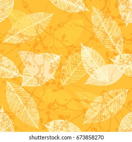 A seamless background pattern of vector skeleton leaves and abstract tree branches in warm yellow, autumnal repeat print