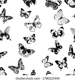 Seamless background of silhouettes various flying butterflies