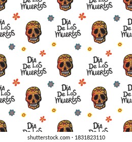 Seamless background. Skull with different colors and an inscription. Flat. Skull with patterns. The inscription "Dia de los muertos", which means "Day of the Dead". Suitable for finishing with textile