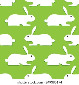 Seamless background with white bunnies with dark green shadows lying opposite one another isolated on light green background. Wallpaper, wrapping paper, textile decoration, invitations, greeting cards