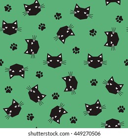 Seamless black cats with paws pattern on green background