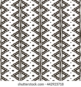 Seamless black and white pattern with ethnic motifs. Vertical stripes, triangular and circular shapes. Abstract geometric ornament in hand drawing style. Vector illustration for modern design