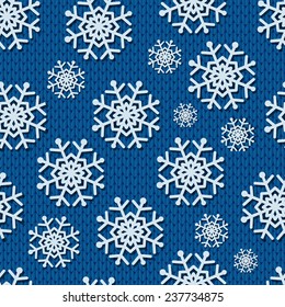 Seamless blue knitted background with paper snowflakes.
