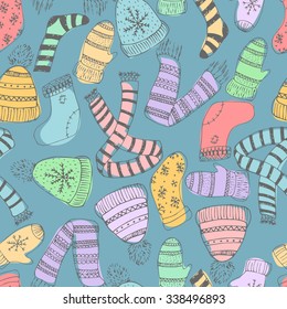 Seamless blue pattern with warm elements. Scarf, hat, mitten. Hand drawn doodle. Vector illustration