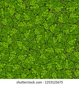Seamless camouflage pattern. The motley green leaves of maple lying on a background of square weaving.